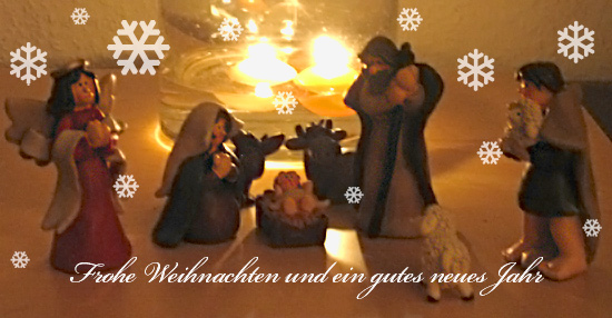 Krippe. Im Hintergrund brennende Kerzen. Fröhliche Weihnachten und ein gutes neues Jahr.